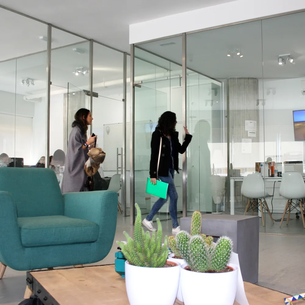 Shared lounge and glass-walled classrooms at Exam Madrid Academy.