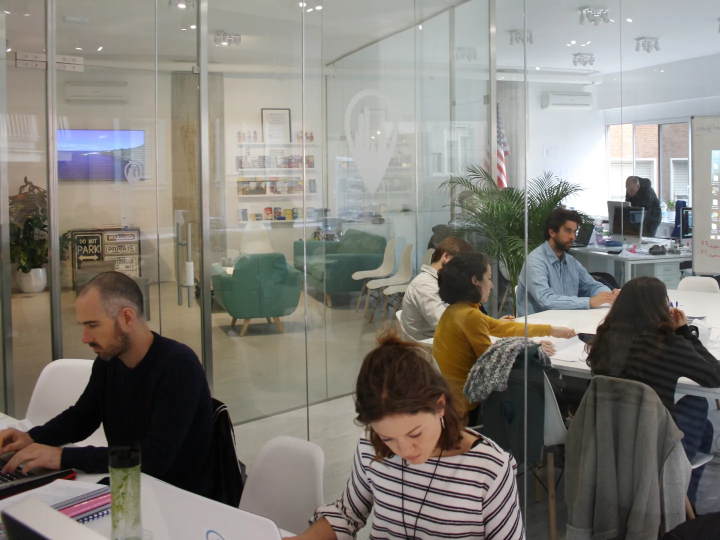 People working with laptops and notebooks at Exam Madrid Academy.