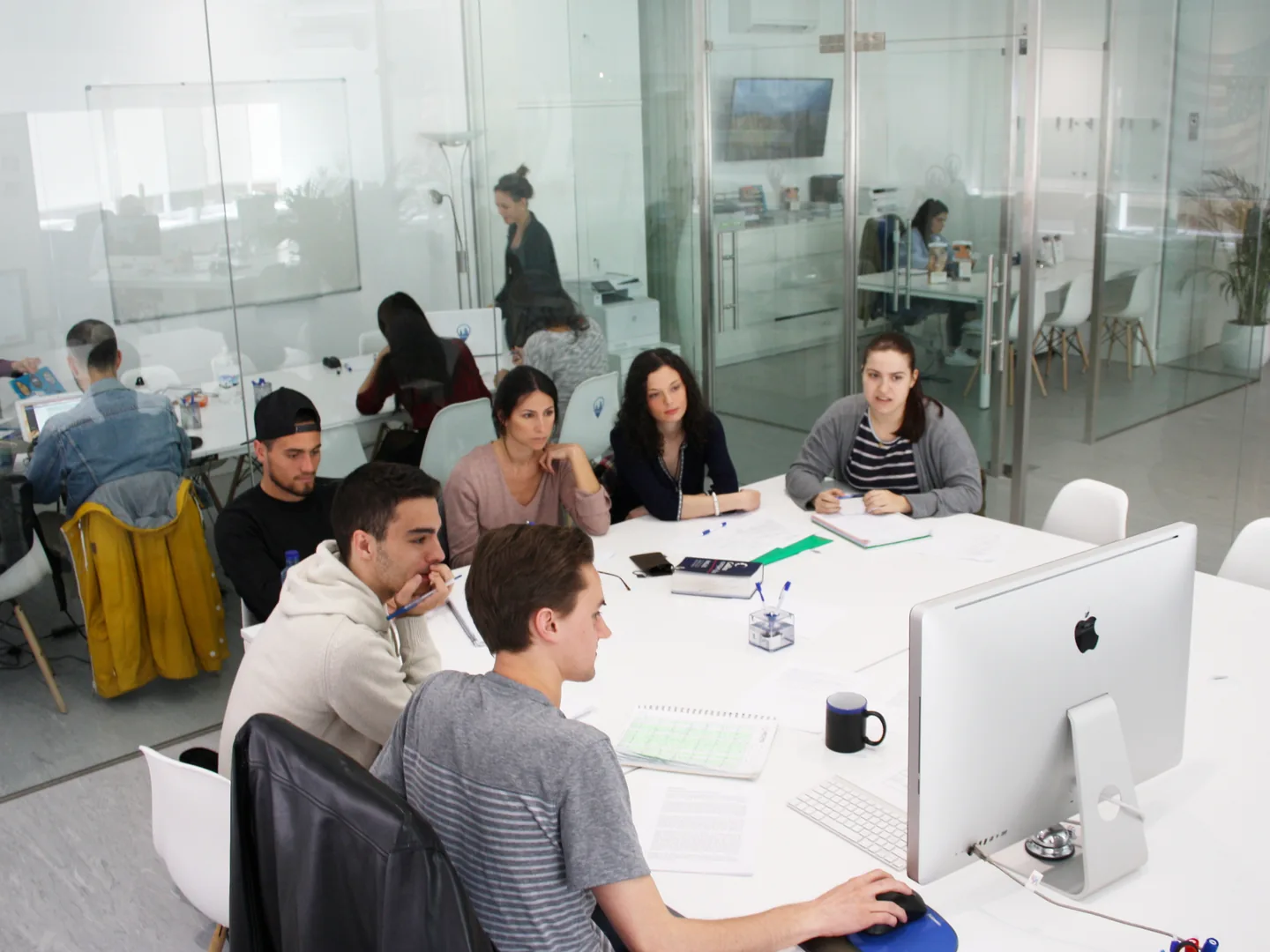 Students working with their teacher in a classroom at Exam Madrid Academy