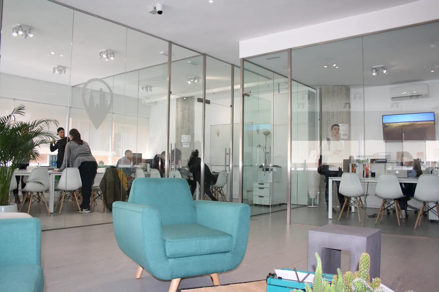 Glass-walled classrooms and seating area at Exam Madrid Academy in Madrid.